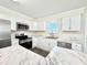 Well-lit kitchen with stainless steel appliances, white cabinets, marble countertops, and luxury vinyl plank flooring at 668 Surl Mount Tirzah Rd, Timberlake, NC 27583