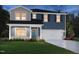 Charming two-story home featuring blue siding, a white garage door, and a cozy front porch at 677 White Birch Ln, Angier, NC 27501