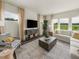Modern living room with large windows, comfortable seating, stylish decor, and a view of the green outdoors at 677 White Birch Ln, Angier, NC 27501