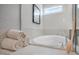 Soaking tub with tile surround, decorative art, and a window allowing for plenty of natural light at 681 Beacon Hill Rd # 38, Lillington, NC 27546