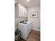 Functional laundry room with overhead cabinets, modern washer and dryer, and wood-look flooring at 681 Beacon Hill Rd # 38, Lillington, NC 27546