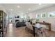 Open-concept living and dining area featuring wood floors, a fireplace, and abundant natural light from several windows at 681 Beacon Hill Rd # 38, Lillington, NC 27546