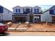 New construction home with a two-car garage in a suburban neighborhood, with worker on site at 725 Deschutes Dr, Garner, NC 27529