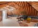 Unfinished attic space with exposed wooden beams, plywood flooring, and a doorway at 7400 Portpatrick Ct, Wake Forest, NC 27587