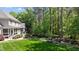 Picturesque backyard featuring a manicured lawn, mature trees, landscaping, and a cozy fire pit area at 7400 Portpatrick Ct, Wake Forest, NC 27587