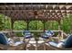 Covered back porch with a wood pergola, wicker chairs, and a wood table with a centerpiece at 7400 Portpatrick Ct, Wake Forest, NC 27587