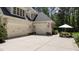 Three car garage with an American flag displayed in front and an outdoor seating area with an umbrella at 7400 Portpatrick Ct, Wake Forest, NC 27587