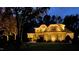 Beautiful home exterior with manicured lawn and landscape lighting at night at 7400 Portpatrick Ct, Wake Forest, NC 27587