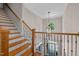 View of a home's foyer from the second story with hardwood stairs and an elegant hanging light fixture at 7400 Portpatrick Ct, Wake Forest, NC 27587