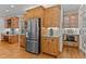 Kitchen with stainless steel refrigerator, custom cabinets, granite countertops, and hardwood floors at 7400 Portpatrick Ct, Wake Forest, NC 27587