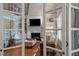 Living room with a fireplace viewed through French doors with lots of natural light at 7400 Portpatrick Ct, Wake Forest, NC 27587