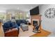 Cozy living room with a fireplace, large TV, blue sofas, and large windows at 7400 Portpatrick Ct, Wake Forest, NC 27587