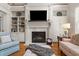 Living room featuring a fireplace, built-in shelving, and hardwood floors at 7400 Portpatrick Ct, Wake Forest, NC 27587