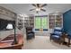 Office with built-in bookshelves, a ceiling fan, a window seat, and two blue leather chairs at 7400 Portpatrick Ct, Wake Forest, NC 27587