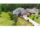 Aerial view of a two-story brick home with an attached two-car garage and a spacious, well-manicured lawn at 7405 Pine Summit Dr, Fuquay Varina, NC 27526