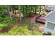 Landscaped backyard featuring mature trees, lawn, and wooden deck at 7405 Pine Summit Dr, Fuquay Varina, NC 27526