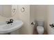 Powder room with a pedestal sink and toilet, featuring neutral walls and ceramic tile at 7405 Pine Summit Dr, Fuquay Varina, NC 27526