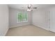 This bedroom features neutral walls, carpet, a ceiling fan, and a window with natural lighting at 7405 Pine Summit Dr, Fuquay Varina, NC 27526