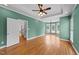 Spacious bedroom featuring hardwood floors, a tray ceiling, a ceiling fan, and a large bay window at 7405 Pine Summit Dr, Fuquay Varina, NC 27526