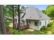 A partial view of the home's rear exterior with a wooden deck, lush landscaping, and a gray shingled roof at 7405 Pine Summit Dr, Fuquay Varina, NC 27526