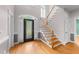 Foyer with hardwood floors, staircase, and decorative glass-paneled front door at 7405 Pine Summit Dr, Fuquay Varina, NC 27526