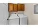 Convenient laundry room with washer, dryer, and overhead cabinetry for storage solutions at 7405 Pine Summit Dr, Fuquay Varina, NC 27526