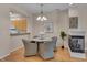 Cozy dining area featuring a fireplace, stylish lighting, and comfortable seating for a pleasant dining experience at 7705 Astoria Pl, Raleigh, NC 27612
