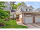 Charming exterior view of home with brick details, lush landscaping, and a two car garage at 7705 Astoria Pl, Raleigh, NC 27612