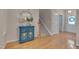 Inviting foyer with hardwood floors, staircase, and a charming blue console table with decorative mirror at 7705 Astoria Pl, Raleigh, NC 27612