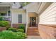 Cozy front porch with brick steps, surrounded by lush greenery and leading to the welcoming front door at 7705 Astoria Pl, Raleigh, NC 27612