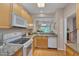 Modern kitchen with wooden cabinetry, granite countertops, and a full suite of appliances at 7705 Astoria Pl, Raleigh, NC 27612