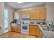 Well-lit kitchen featuring wooden cabinets, granite countertops, and modern appliances at 7705 Astoria Pl, Raleigh, NC 27612