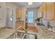 Bright kitchen with granite countertops, stainless steel sink, and wooden cabinets, perfect for cooking at 7705 Astoria Pl, Raleigh, NC 27612
