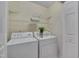 Functional laundry room with washer, dryer, shelving, and storage space at 7705 Astoria Pl, Raleigh, NC 27612