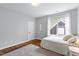 Bedroom with hard wood floors, gray walls, a large bright window, white bed linens and a gray area rug at 811 E Lane St, Raleigh, NC 27601