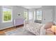 Bright bedroom with a purple dresser, patterned bedding and area rug with lots of light from three windows at 811 E Lane St, Raleigh, NC 27601