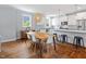 A modern dining room with a wooden table, white cabinets and stainless steel appliances at 811 E Lane St, Raleigh, NC 27601