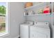 Bright laundry room with washer, dryer, storage shelves and a window with outside view at 811 E Lane St, Raleigh, NC 27601