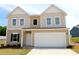 Two-story home featuring a two-car garage and a well-manicured lawn, offering a blend of comfort and curb appeal at 944 Bombardier Ln, Spring Hope, NC 27882