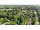 An aerial view displays lush green canopy covering a quiet neighborhood at 1005 Stuart Dr, Mebane, NC 27302