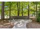 Beautiful backyard with curved seating, brick pavers, and lots of trees for natural shade at 1005 Stuart Dr, Mebane, NC 27302