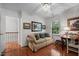 Charming bedroom featuring hardwood floors, bright window, comfortable couch, and access to the upstairs landing at 1005 Stuart Dr, Mebane, NC 27302