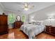Spacious bedroom with hardwood floors, two windows with views, and traditional furnishings at 1005 Stuart Dr, Mebane, NC 27302