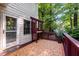 Cozy outdoor deck with a decorative trellis, textured rug, and a view of the lush surrounding greenery at 1005 Stuart Dr, Mebane, NC 27302