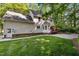 Back of home with a brick foundation, patio, attached garage, a deck, and beautiful lawn at 1005 Stuart Dr, Mebane, NC 27302