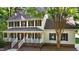 Beautiful two-story home with inviting front porch, black shutters and ample greenery in a tree-lined yard at 1005 Stuart Dr, Mebane, NC 27302