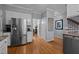 Eat in kitchen with stainless steel refrigerator, hardwood floors, granite countertops, and white cabinets at 1005 Stuart Dr, Mebane, NC 27302
