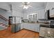 Traditional style kitchen with granite counters, stainless appliances, and natural light from the window above the sink at 1005 Stuart Dr, Mebane, NC 27302
