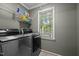 Well-equipped laundry room with modern stainless steel washer and dryer plus shelving and window at 1005 Stuart Dr, Mebane, NC 27302