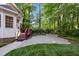 Beautiful backyard with a stone patio, lush lawn, garden, and a walkway up to the deck at 1005 Stuart Dr, Mebane, NC 27302